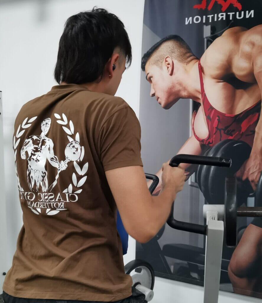 beginnende sporter met gymlogo tshirt traint voor een motiverende poster van een bodybuilder