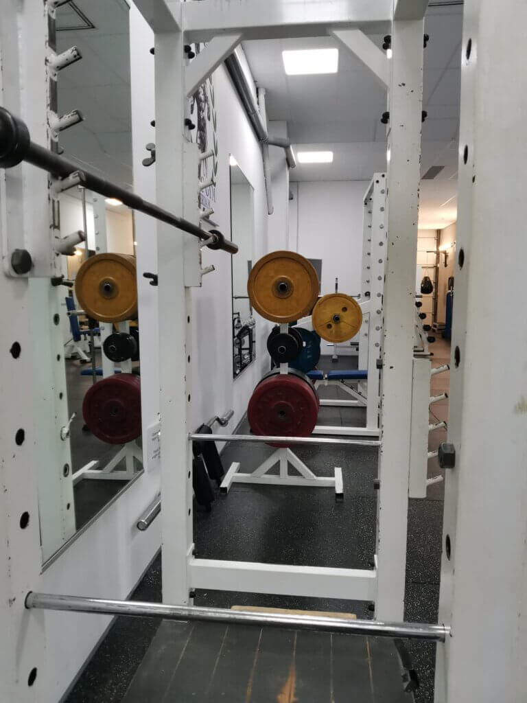 Squat rack met Olympische schijven op een rek. Een professionele en georganiseerde trainingsomgeving.