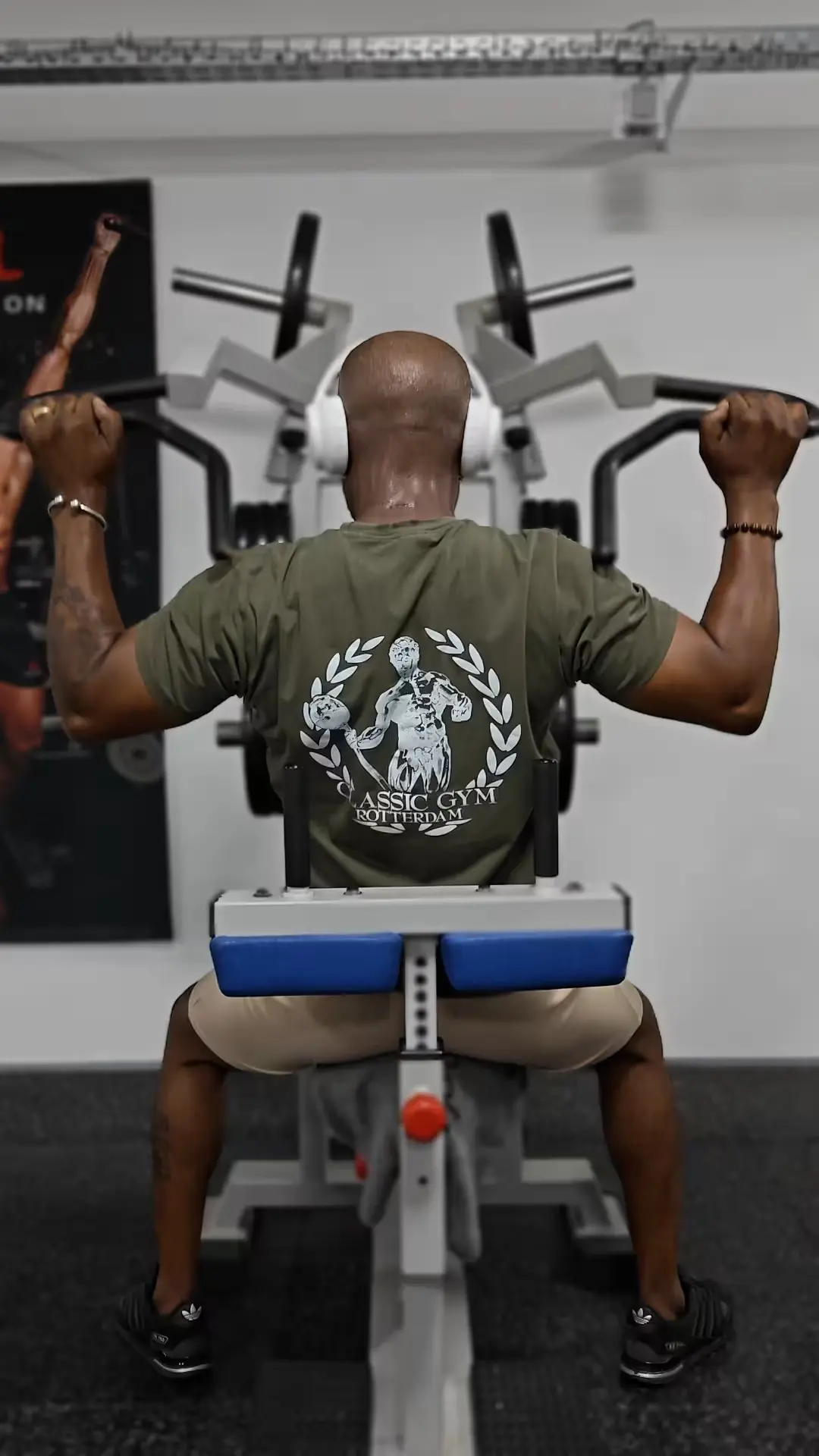 Atleet doet lat pulldown op freeweight P&A‑machine terwijl hij een Classic Gym‑shirt draagt